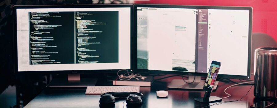 two black computer monitors on black table
