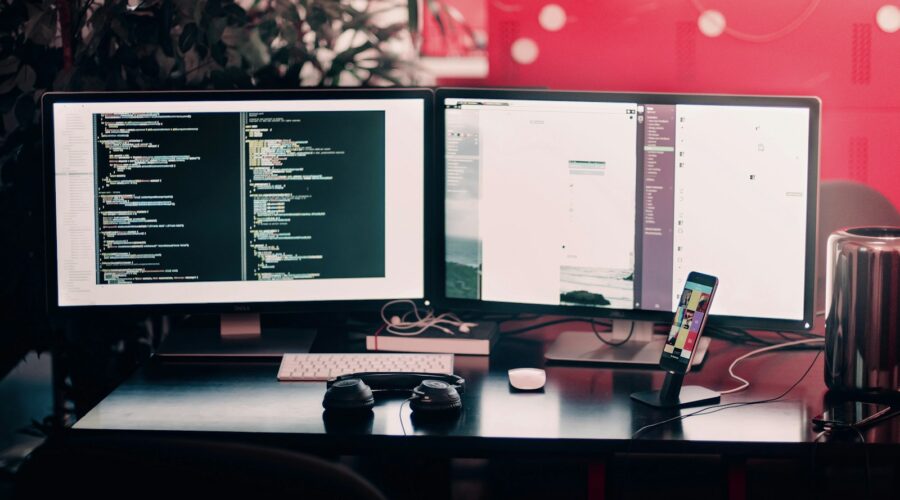 two black computer monitors on black table